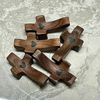 Wooden crosses with heart shapes on a gray surface