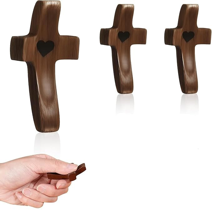 Wooden crosses with heart cutouts, a hand holding one, and white bags with cross designs.