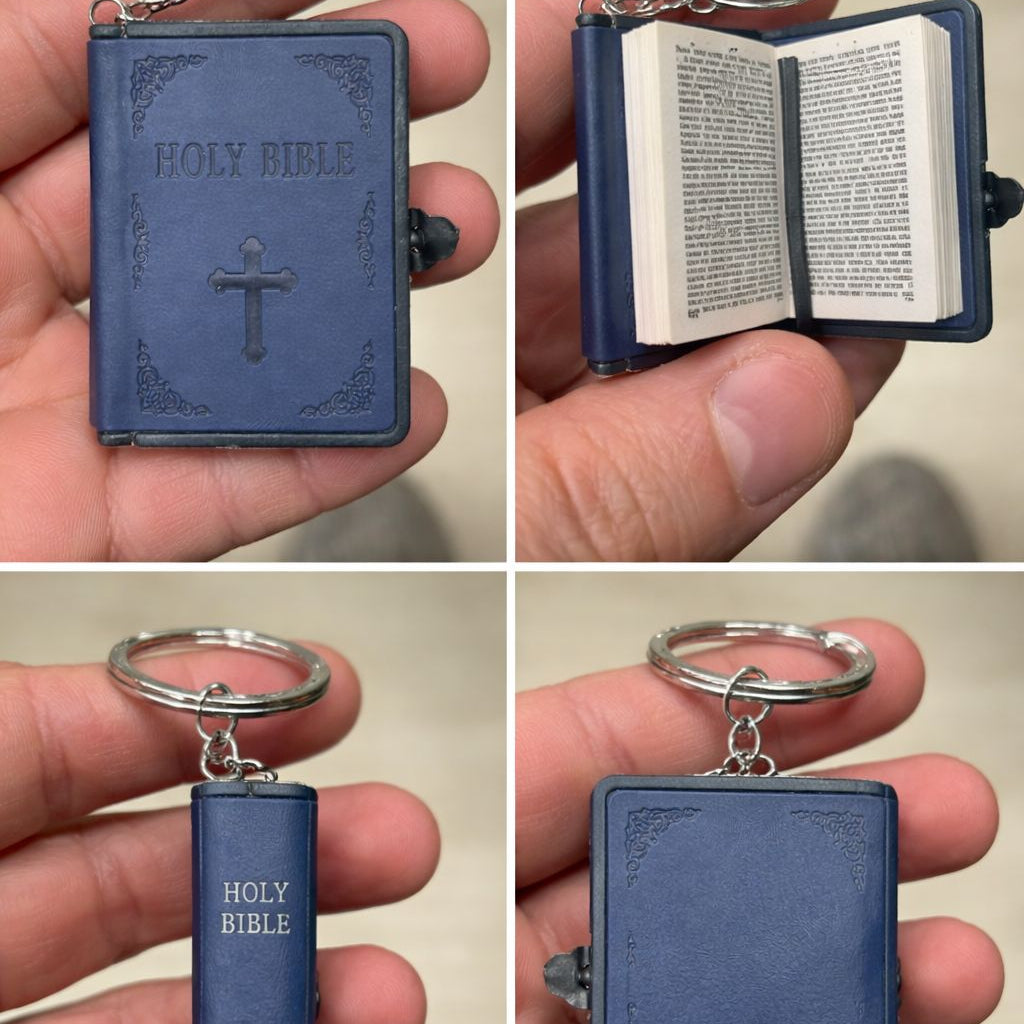 Miniature blue 'HOLY BIBLE' keychain held in a hand.
