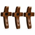 Three wooden crosses with heart shapes on a white background