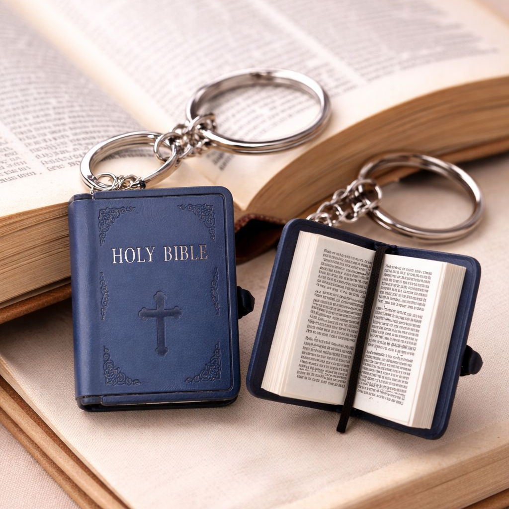 Two blue 'Holy Bible' keychains on an open book