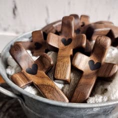 Wooden crosses with heart shapes in a metal bucket