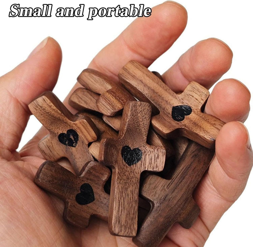 A hand holding several small wooden cross pieces with black heart engravings, with the text 'Small and portable' at the top on a white background.